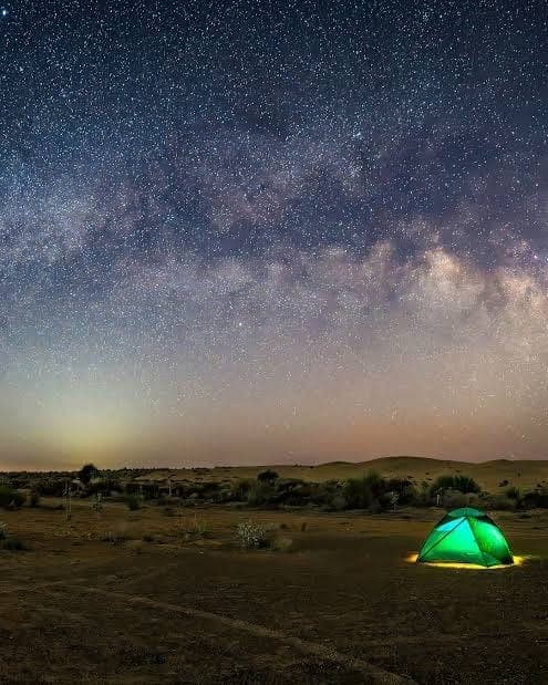 Green tent under desert stars